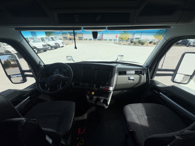 Kenworth T680 interior view through windshield showing dash, steering wheel, and front seats.