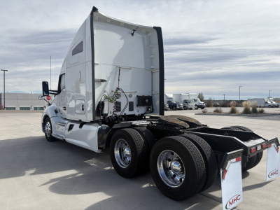Kenworth truck tractor rear view with open sleeper cab, showcasing dual rear axles and connection area; no label text visible.