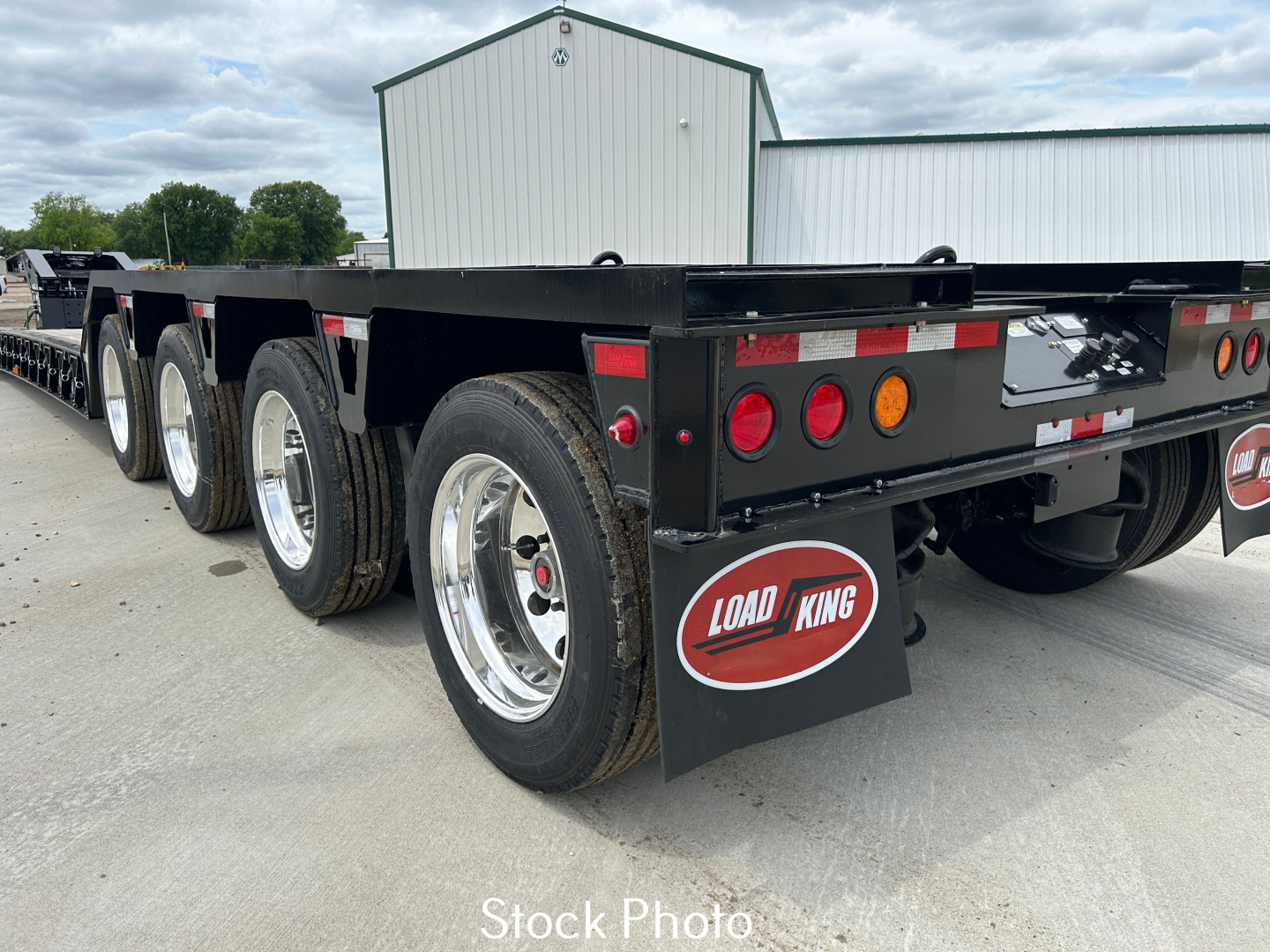 Load King 554-Quad-9'Wide-24'LDH trailer rear view showing triple-axle configuration, black frame, Load King mud flaps, taillights, and reflective markers.