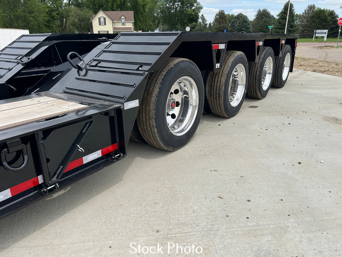 Load King trailer side view showing multiple axles with aluminum wheels and black frame, 9' wide LDH, 24" stretch.