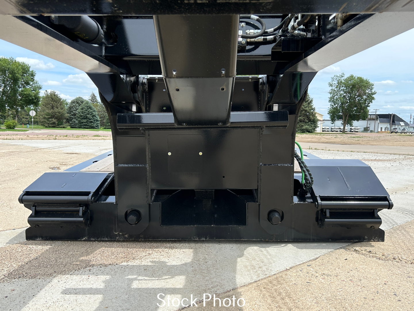 Load King trailer undercarriage showing lowboy with dual tracks and structural center support; visible hydraulics and frame components from front/floor level.