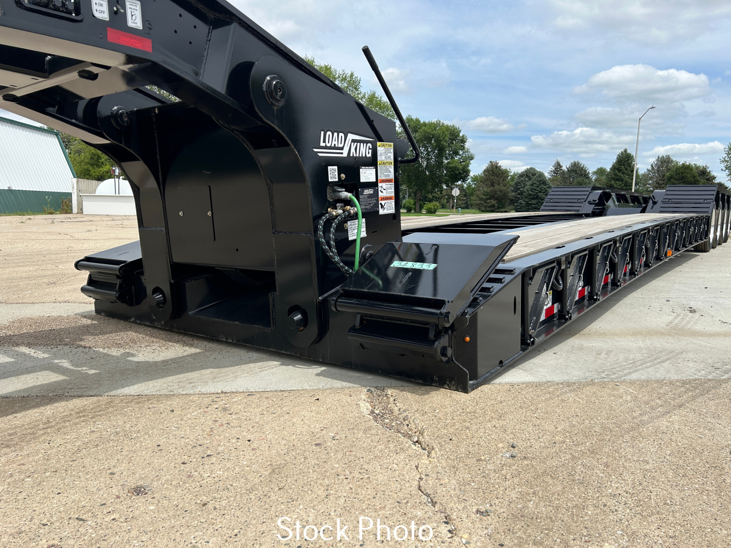 Load King trailer lowboy showing hydraulic gooseneck and long flat deck with multiple axles and Load King logo.