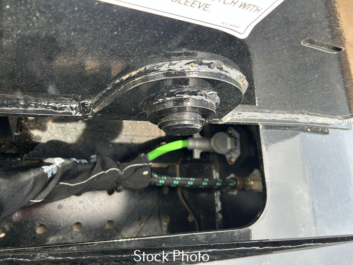 Trailer hitch area with hydraulic line and quick-connect in Focus showing Stock Photo label on the Load King trailer LDH