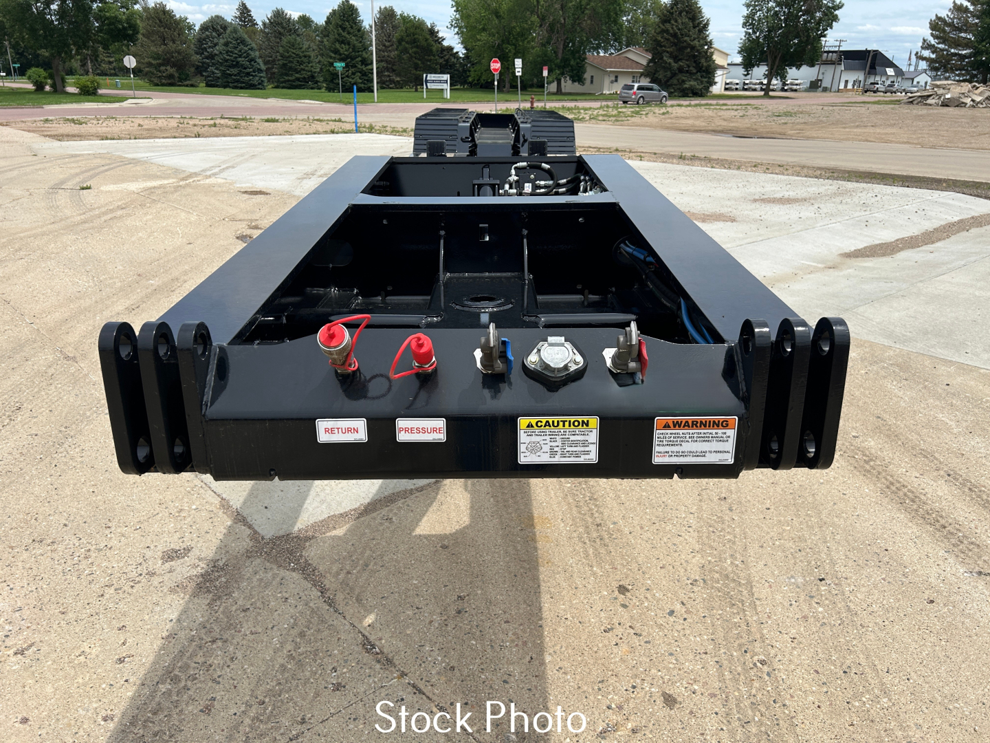 Load King trailer hitch and rear platform showing mounting pins, safety decals, and warning labels.