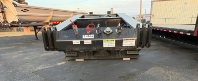 Load King trailer hitch area showing safety chains, labels, and hitch pins with warning decals.
