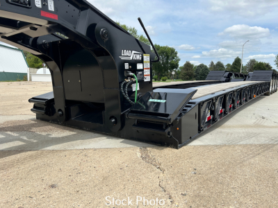 Load King trailer lowboy showing hydraulic gooseneck and long flat deck with multiple axles and Load King logo.