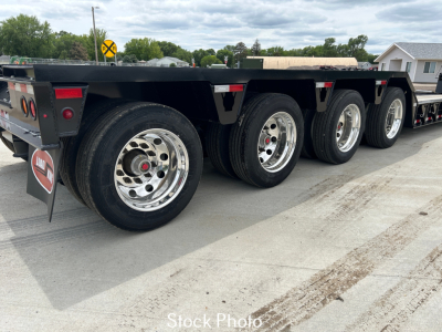Trailer axle group: Load King lowboy trailer with multiple wheels and polished chrome rims, side rails, and rear light assemblies visible.