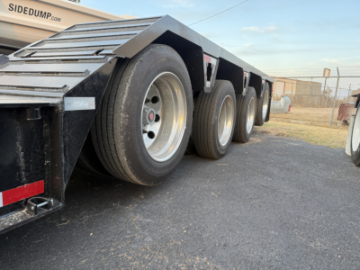 Load King trailer side showing multiple axles and heavy-duty tires with LDH labeling on the equipment.