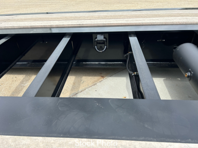 Trailer deck frame with open storage area showing metal I-beam chassis and hinge latch, Load King trailer components visible, stock photo label present.
