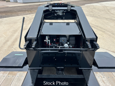 Load King trailer component view showing hydraulic system and chassis, with platform extensions folded out. Black steel frame, hydraulic hoses, control motors visible in center rear, metal decking on sides.