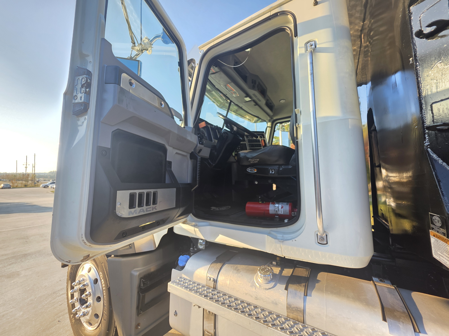 Truck cab interior of a 2022 Mack GRANITE dump truck showing open driver door and dashboard area.
