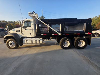Truck: 2022 Mack GRANITE dump truck with black dump bed, side profile showing dual rear axles, chrome fuel tanks, and front cab details.