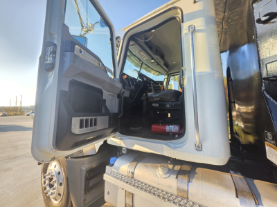 Truck cab interior of a 2022 Mack GRANITE dump truck showing open driver door and dashboard area.