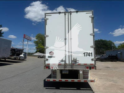 Rear of a white box trailer with double doors, taillights, and bumper. The doors have metal hinges, latches, and a small red circular light. License plate area and reflective tape along bottom. The number 1741 printed on the lower right of 