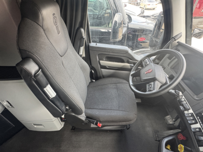 Kenworth T680 interior driver seat and steering wheel view with cab controls visible.