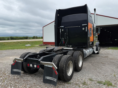 Kenworth W-900L AeroCab tractor rear view showing fifth wheel and dual rear axles with mud flaps and fuel tanks.