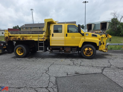 Chevrolet Kodiak C7500 dump truck side view showing yellow cab and dump bed with front-mounted equipment and dual rear wheels.
