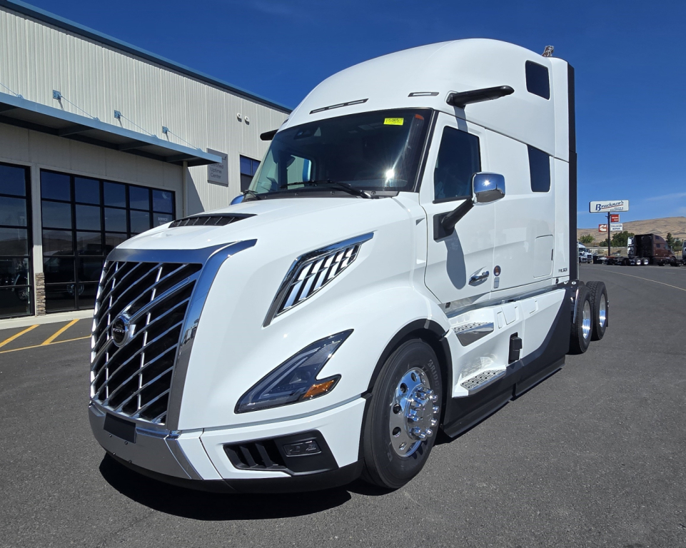 Volvo VNL64T860 conventional sleeper truck in white, angled front view with chrome wheels and bold grille.
