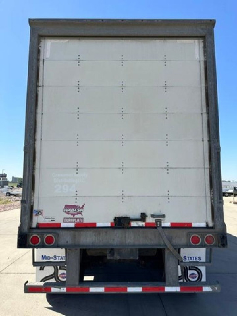 Rear view of a white 2016 Wabash trailer van showing empty cargo door and rear bumper with lights and reflective tape.