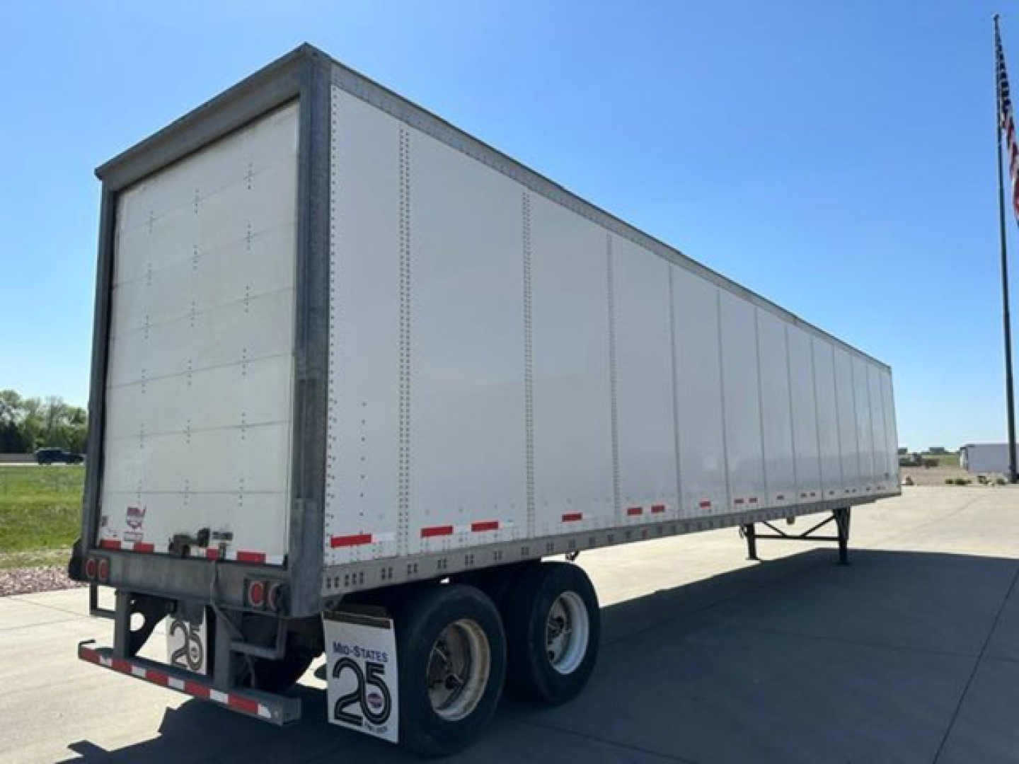 Trailer side view of a 2016 Wabash van trailer showing riveted aluminum walls and dual rear wheels; no visible branding text on side.