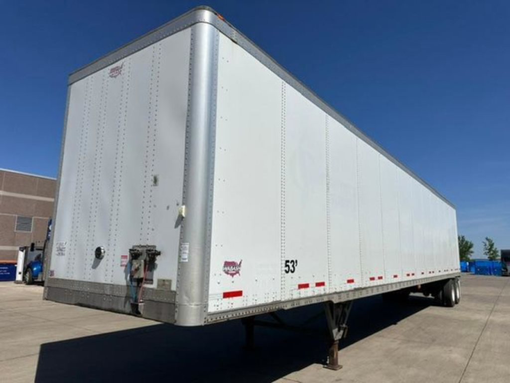 Trailer side view showing a 53' white Wabash van trailer with tandem rear wheels and landing gear.