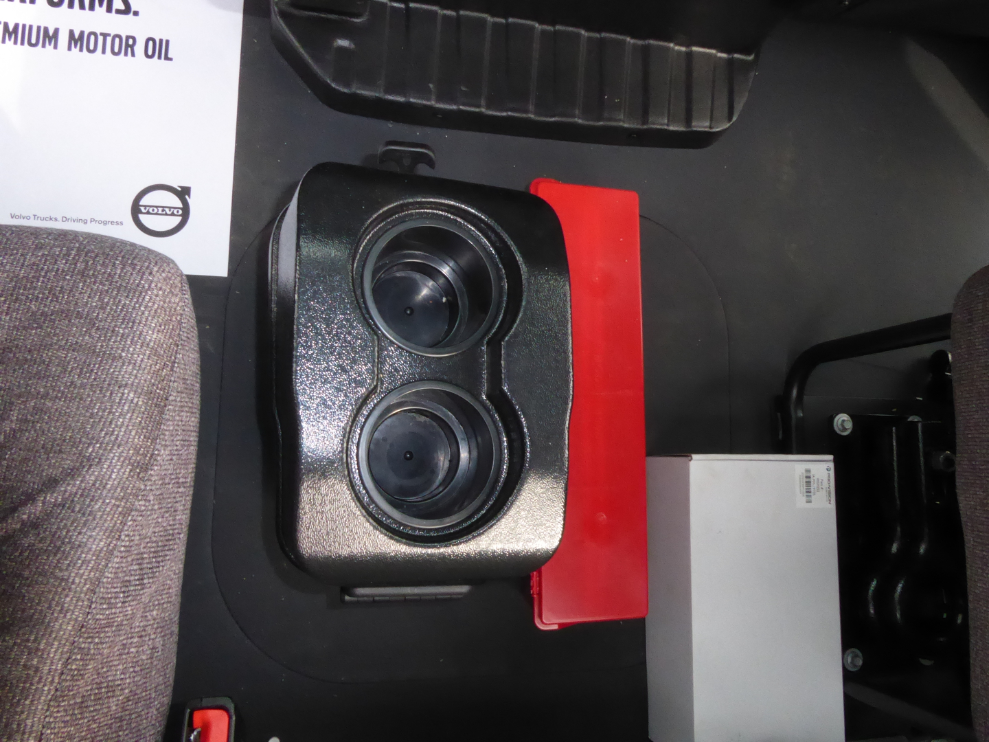 Mack MD7 cab interior showing dual cupholders and storage area near seat base