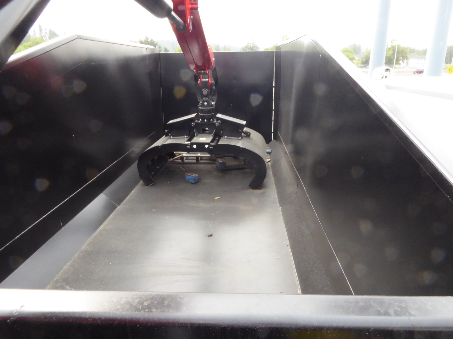 Mack MD7 grapple truck bed showing hydraulic grapple attachment in bed with black steel sides.