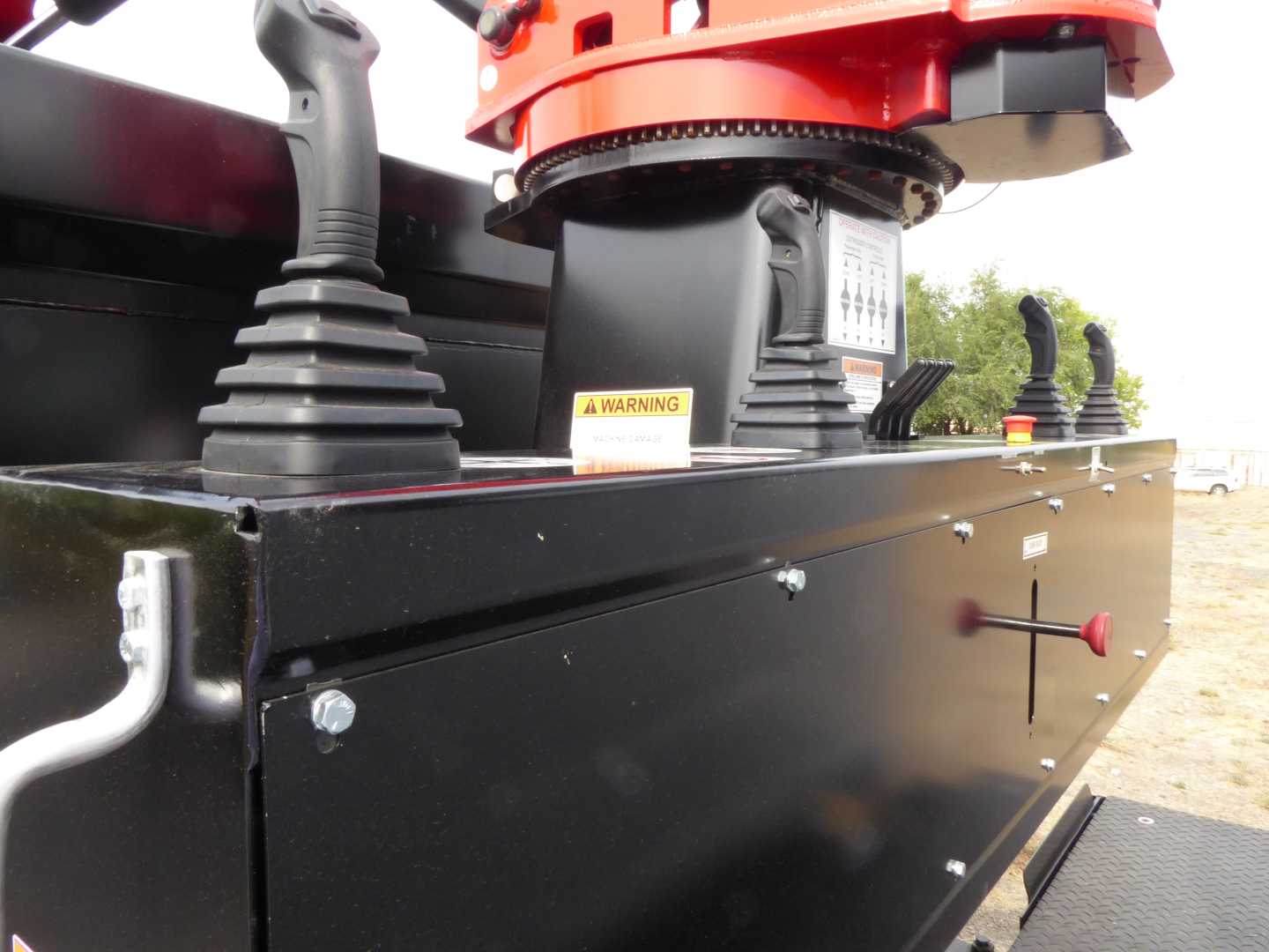 Mack MD7 component view showing hydraulic pedestal and control box with warning label, side of flatbed truck