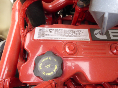 Mack MD7 engine bay showing diesel engine oil cap and label plate on red valve cover.