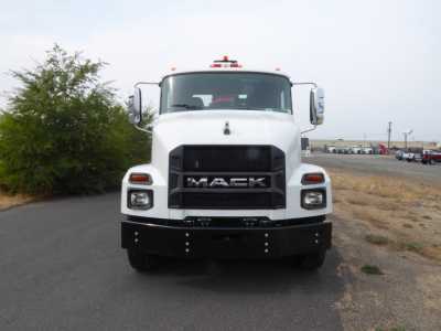 Front view of white 2025 Mack MD7 truck with large grille, headlights, and Mack emblem; front bumper and large mirrors visible.