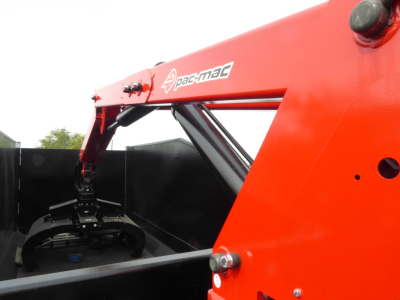 Mack MD7 grapple truck component showing Pac-Mac hydraulic arm and grapple attachment with red boom and black grapple mechanism.