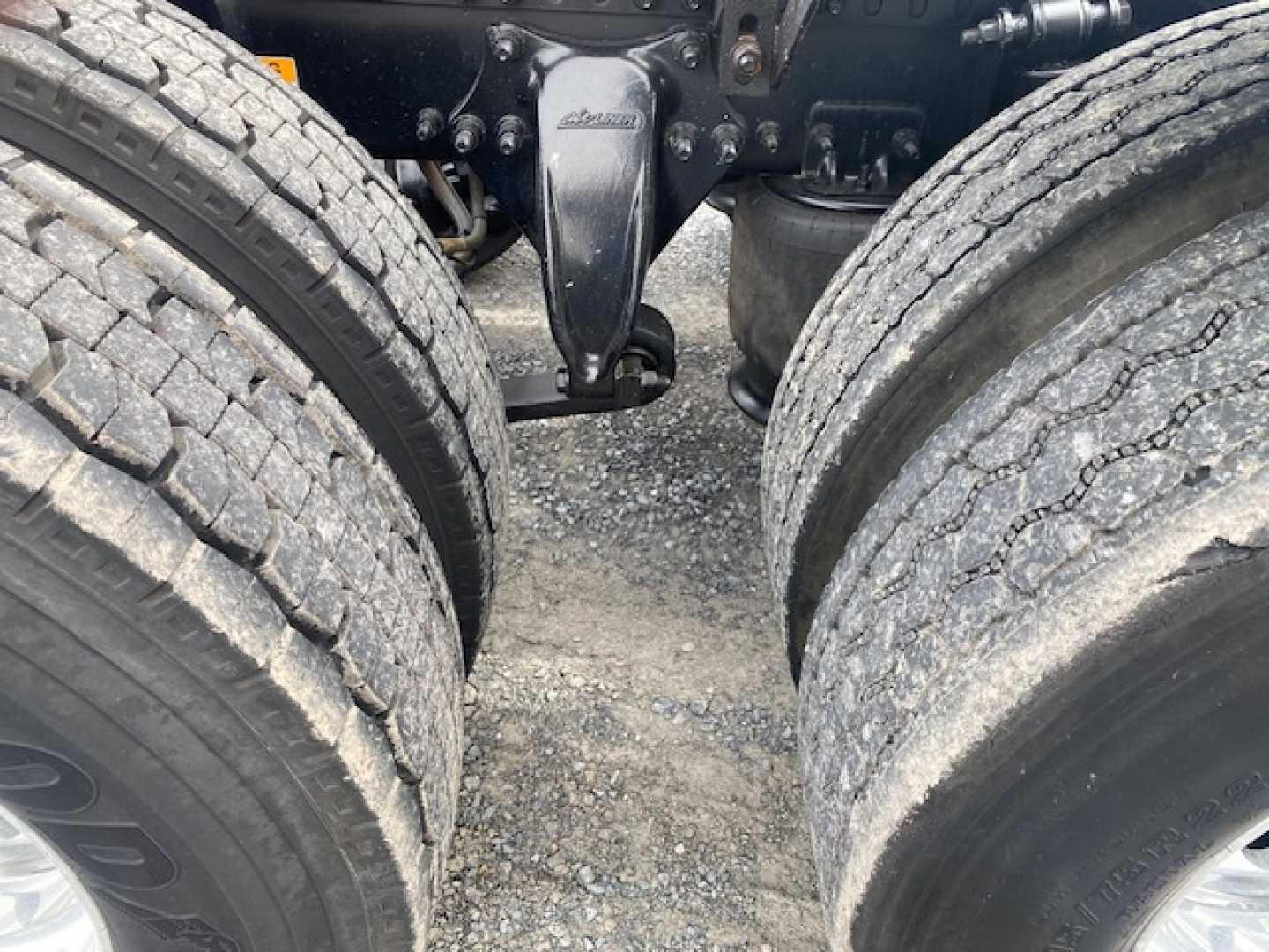 Freightliner Cascadia 113 truck chassis with dual rear axles and suspension components visible between tires.