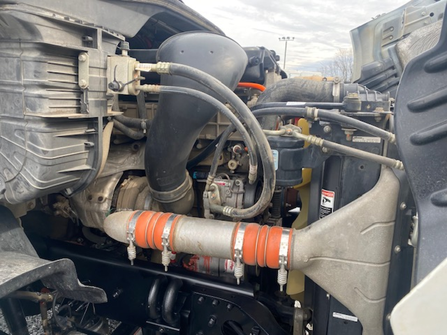 Freightliner Cascadia 113 engine bay showing intake tubing and front engine components.