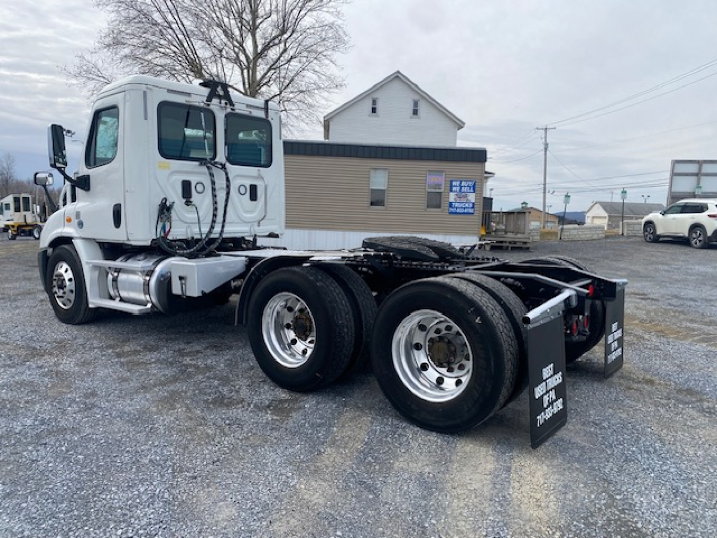 Freightliner Cascadia 113 tractor cab in a used condition showing chassis and dual rear axles with mud flaps