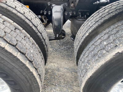 Freightliner Cascadia 113 truck chassis with dual rear axles and suspension components visible between tires.