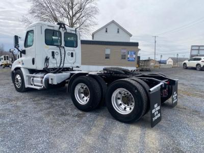 Freightliner Cascadia 113 tractor cab in a used condition showing chassis and dual rear axles with mud flaps