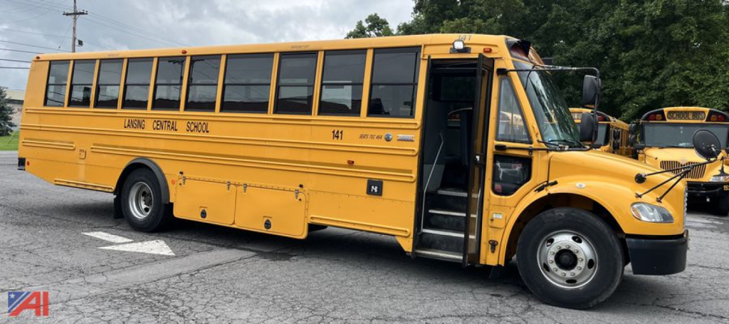 School bus exterior showing open front door, yellow color, ‘LAGG? CENTRAL SCHOOL’ lettering and bus number on side, Freightliner Thomas B2B-C2 style.