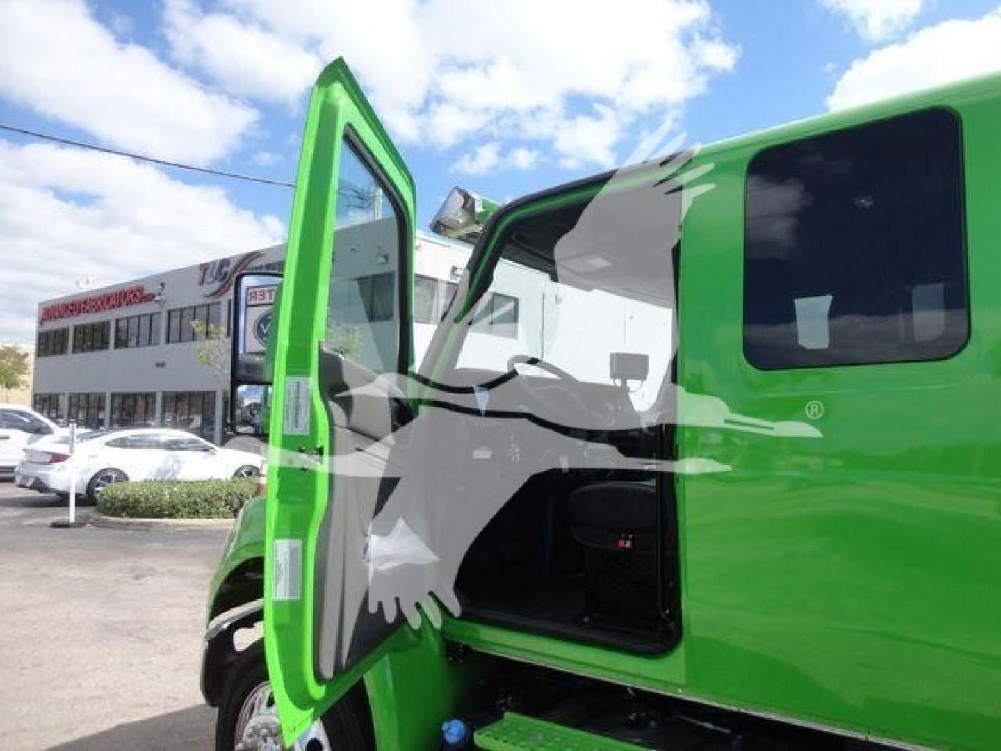 Green International MV truck with open door showing interior and step-side cab, stock MV607STEPSIDEFM.