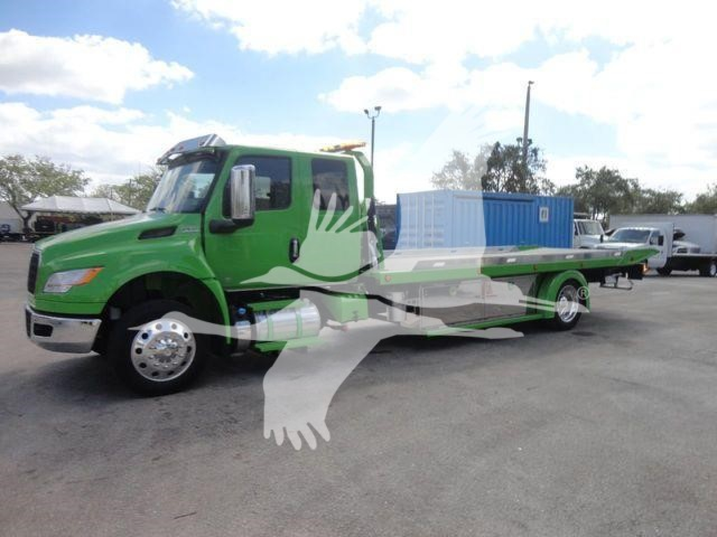 Tow truck/rollback truck with bright green cab and blue container in bed, side view showing extended flatbed and stabilizer legs.