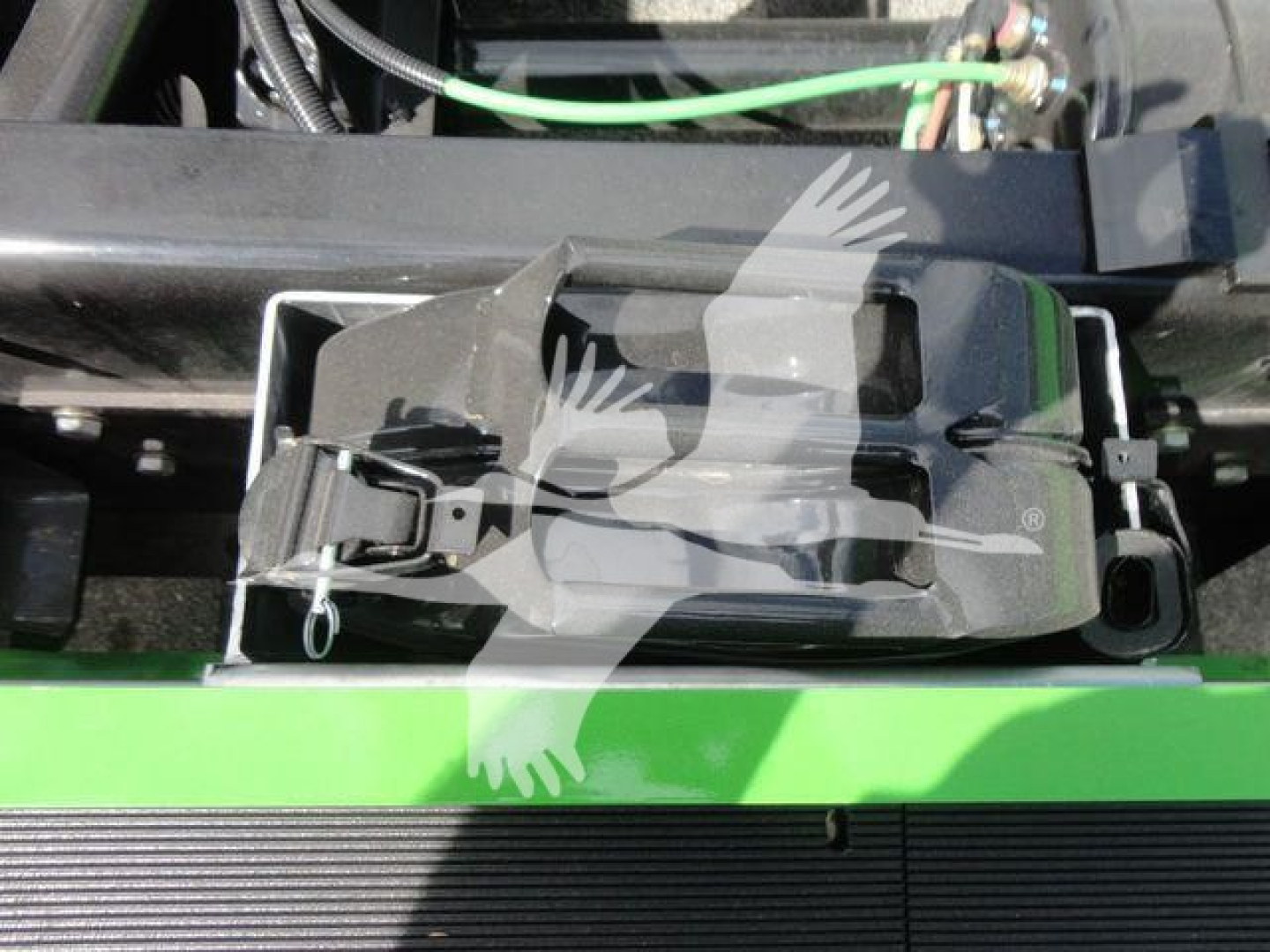 Truck deck area showing a step-side mechanism with a black plastic latch and green body paint. visible labels include no legible text beyond mechanical components.