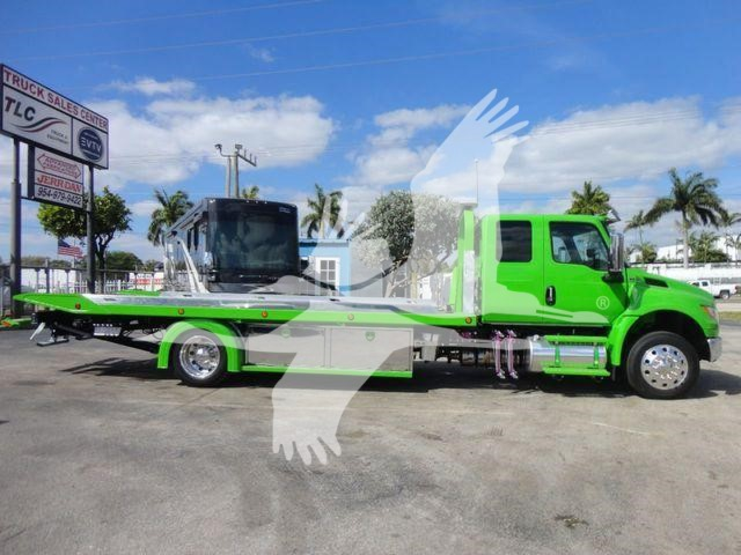 Tow truck with bright green cab and matching flatbed, MV607STEPSIDEFM stock number, low side profile, International brand, rollback truck