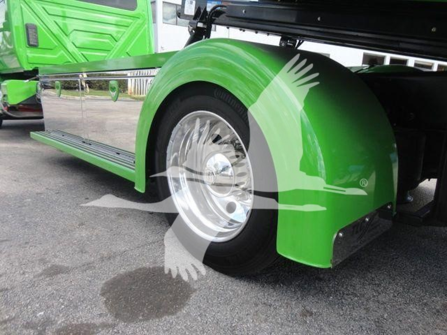 New 2027 International MV rollback truck showing green fender and front wheel area with chrome wheel cover and step-side design.