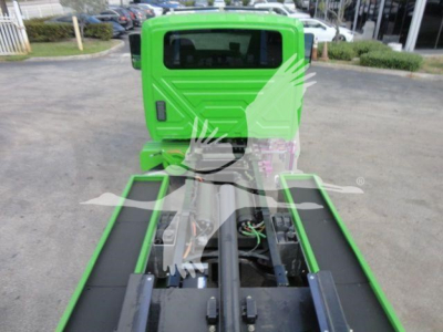 Green 2027 International MV rollback truck chassis rear view showing open frame and drivetrain, with cab in bright green.