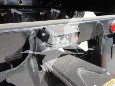 Trailer hitch or mounting frame with a rectangular electrical connector housing and surrounding metal framework. Visible labels and a small red circular light on the right.