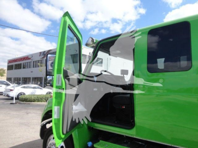 Green International MV truck with open door showing interior and step-side cab, stock MV607STEPSIDEFM.