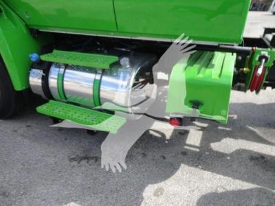 Green International MV truck side showing chrome fuel tank, green steps, and side equipment.