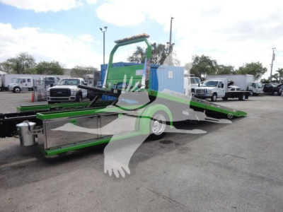 Truck with green and black rollback equipment and a blue cab unit visible in a dealership lot; MV607STEPSIDEFM stock number.