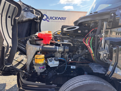 Freightliner Cascadia126 engine bay showing coolant reservoir and air filter assembly with wiring harness in view.