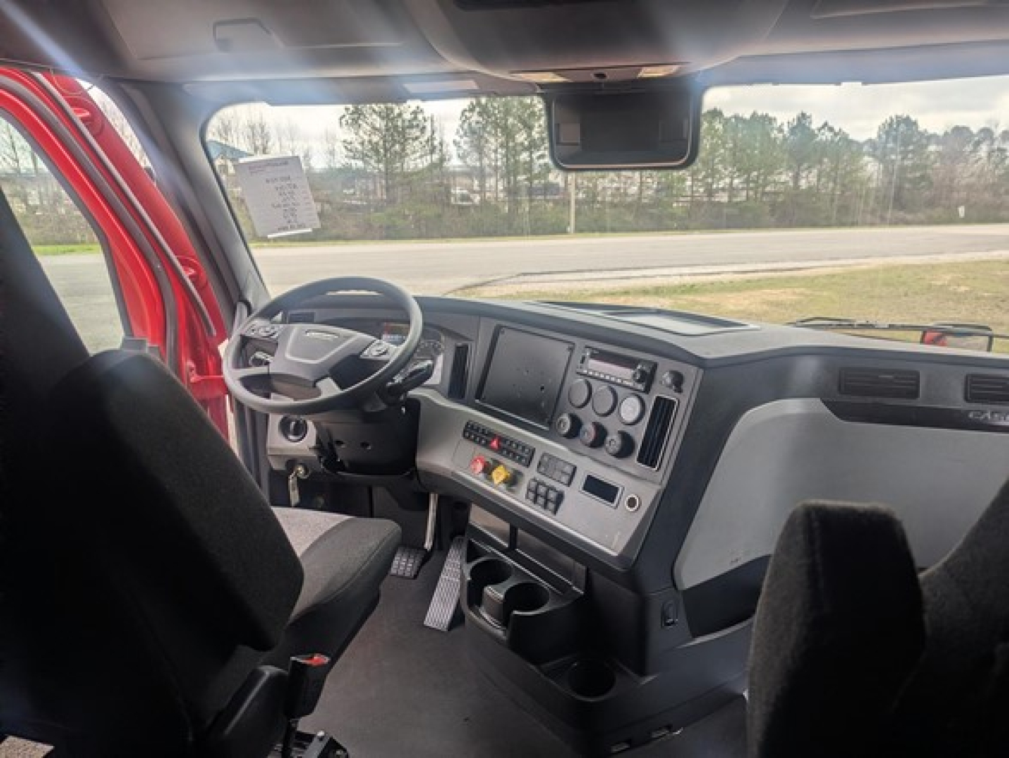 Freightliner Cascadia 126 cab interior showing steering wheel, dashboard, and driver's seat.
