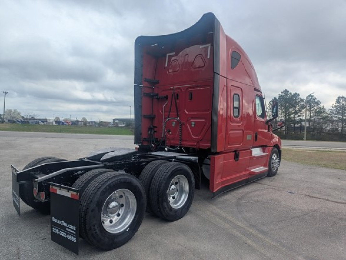 Truck cab and chassis of a red 2022 Freightliner Cascadia 126 with sleeper cab rear view showing dual rear axles